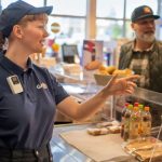 Axis W111 body worn camera worn by a retail employee assisting a customer