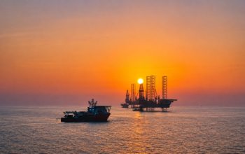 Offshore drilling rigs at sunset representing ADNOC’s AI-enabled drilling operations in the UAE
