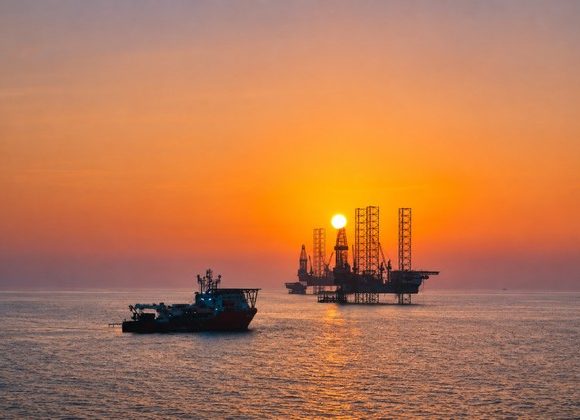 Offshore drilling rigs at sunset representing ADNOC’s AI-enabled drilling operations in the UAE