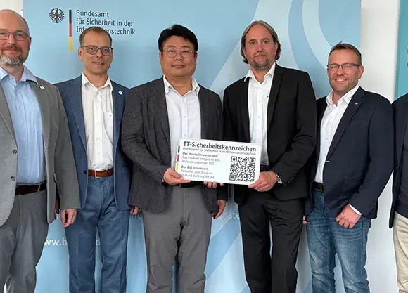 Hanwha Vision representatives holding the BSI IT Security Label certificate