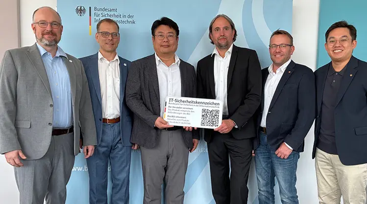 Hanwha Vision representatives holding the BSI IT Security Label certificate